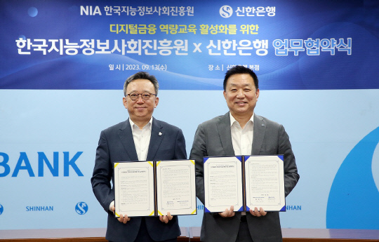 13일 서울시 중구 소재 신한은행 본점에서 진행된 디지털금융 역량교육 활성화를 위한 업무협약식에 참석한 정상혁 신한은행장(왼쪽), 황종성 한국지능정보사회진흥원장이 기념촬영을 하고 있다. 신한은행 제공.